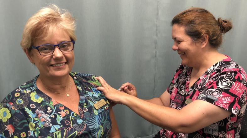 Innisfail Family Health Assistant Practice Manager – Annette Ah Shay (left) receives her COVID-19 vaccine from Registered Nurse Michelle McCarthy